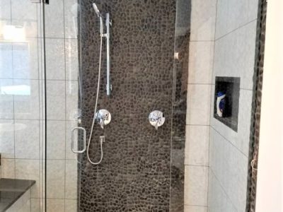 Black Pebble Mosaic Tile Installation in Shower Floor and Wall